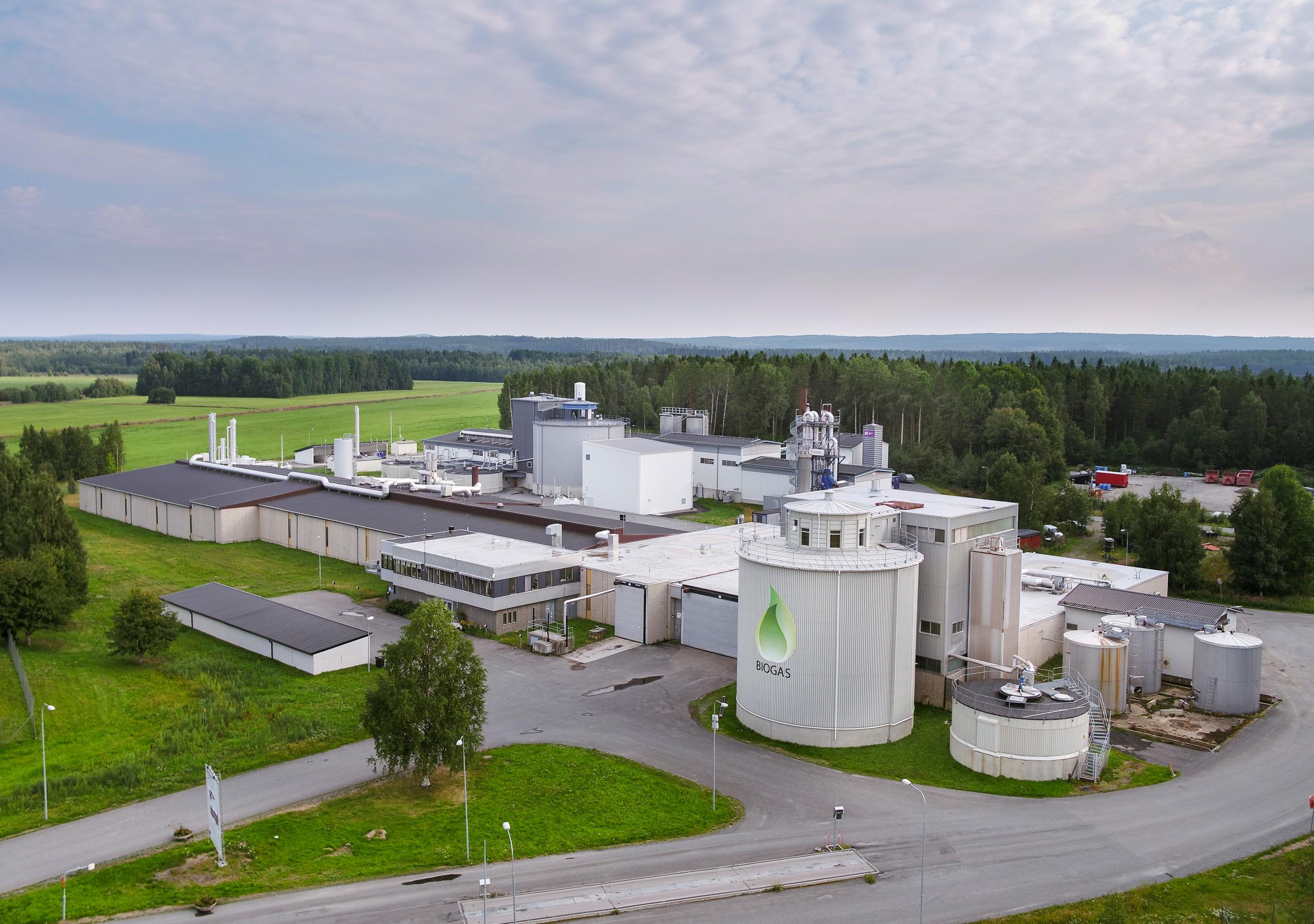 Industrial buildings for biogas production in a forest landscape.