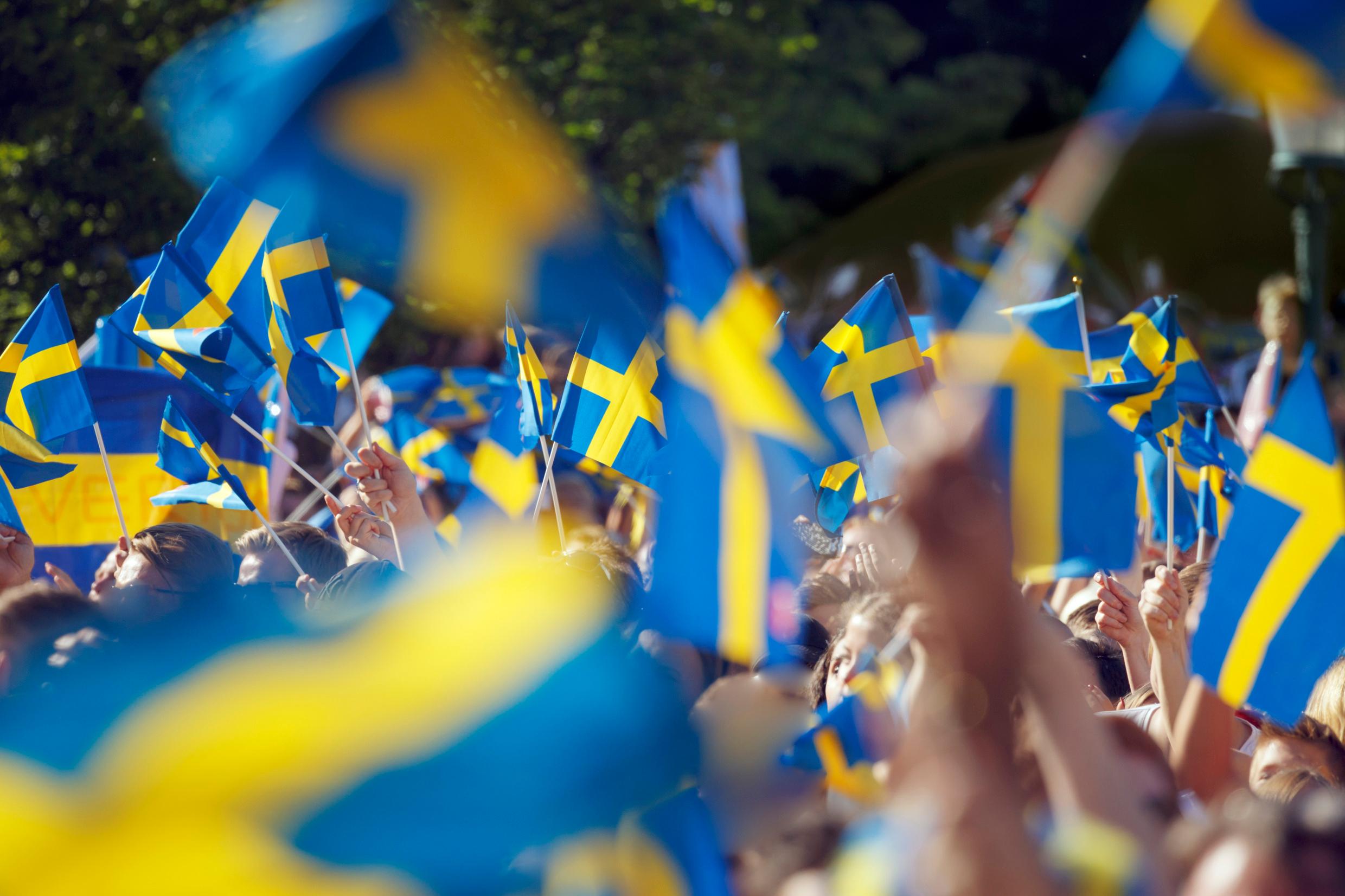 أشخاص يحملون أعلام السويد