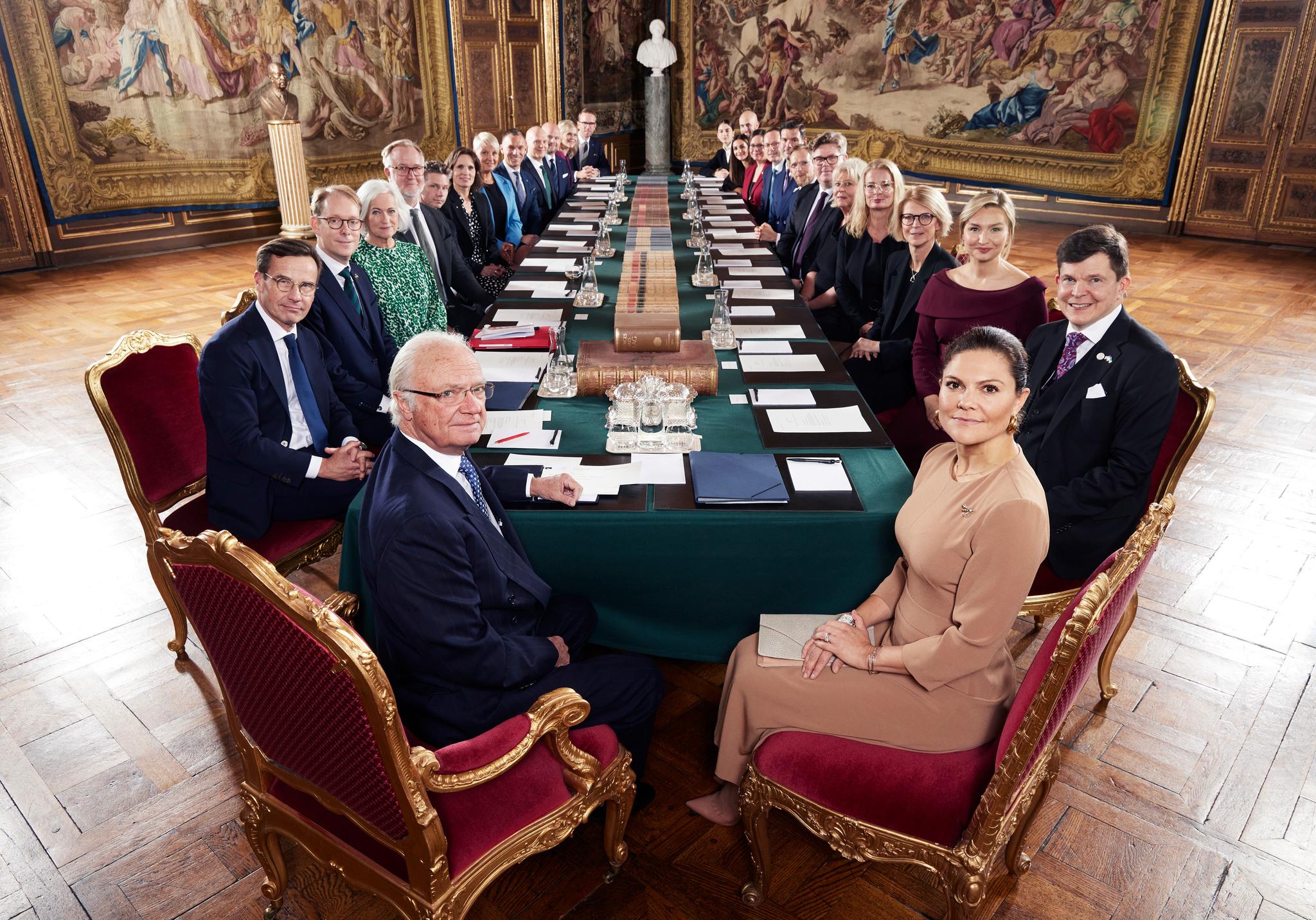الملك كارل السادس عشر غوستاف وولية العهد الأميرة فيكتوريا يجلسان على مائدة أثناء إنعقاد مجلس تغيير الحكومة. 